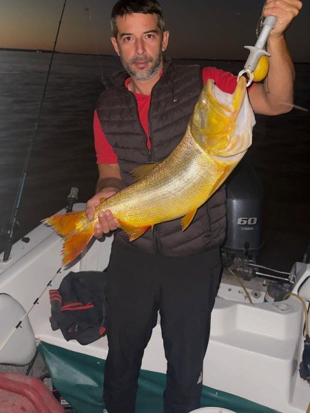 Pescador muestra un dorado de noche en la lancha, Esquina, Corrientes