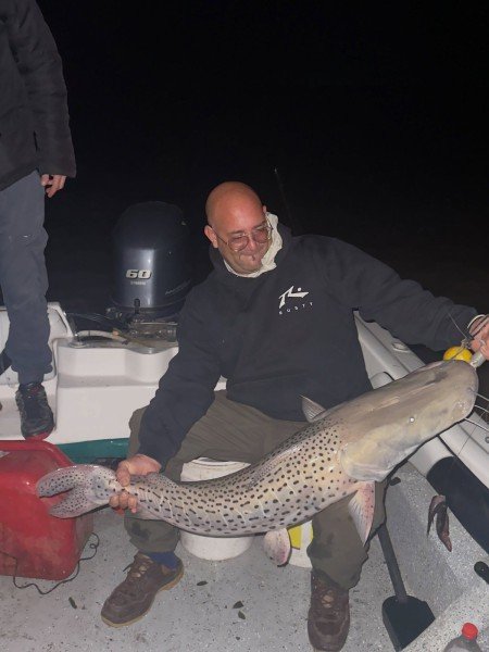 Pescador sentado en la lancha con un surubí de noche, Esquina, Corrientes