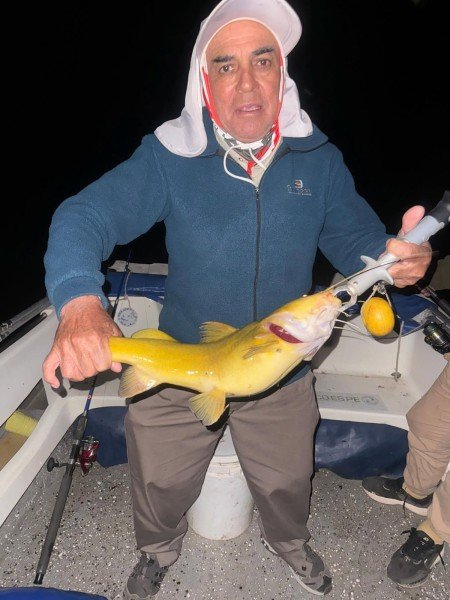Pescador muestra un pez de cuero durante la pesca nocturna, Esquina, Corrientes