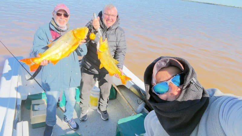 Dos pescadores, cada uno con su dorado, y un amigo en primer plano, Esquina, Corrientes